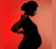 Pregnant black woman in shadow on a red background